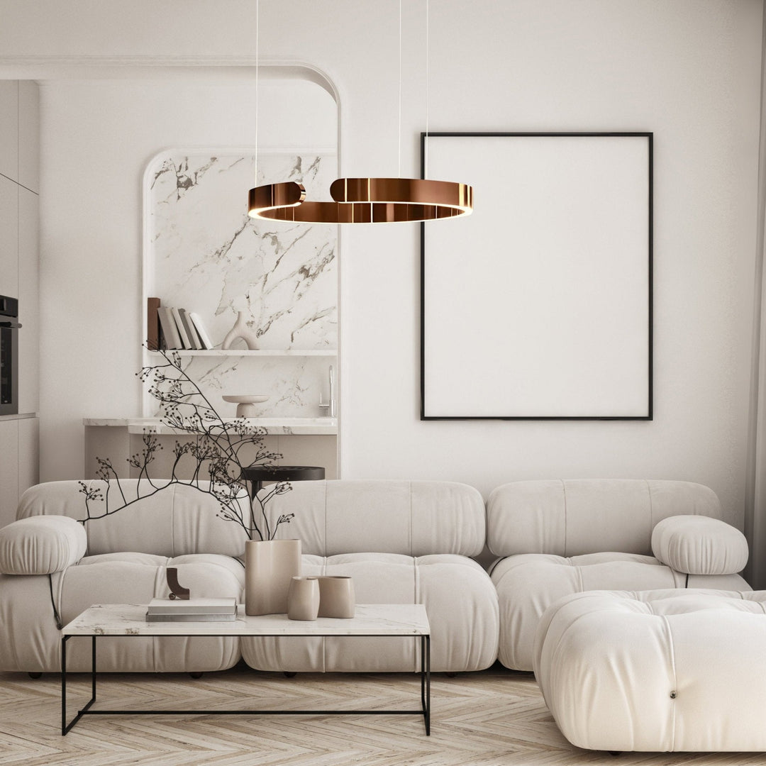 Modern copper metal pendant light with a circular design, suspended over a living room coffee table.