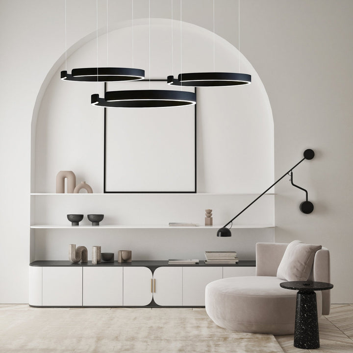 Three black metal pendant lights with white LED strips hang above a modern living space.