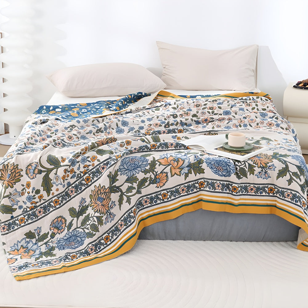 Meadow Bliss Boho Floral Blanket with a floral pattern in blue, orange, and green on a cream background.