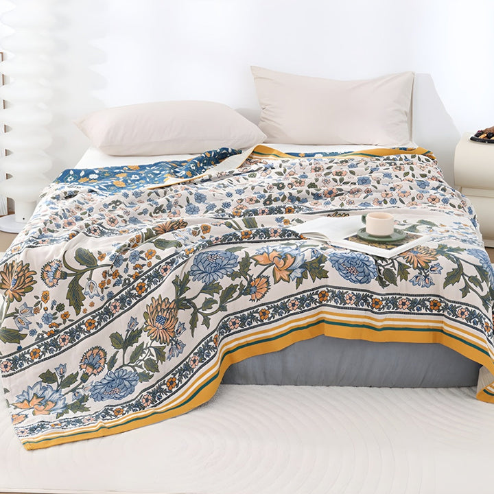 Meadow Bliss Boho Floral Blanket with a floral pattern in blue, orange, and green on a cream background.