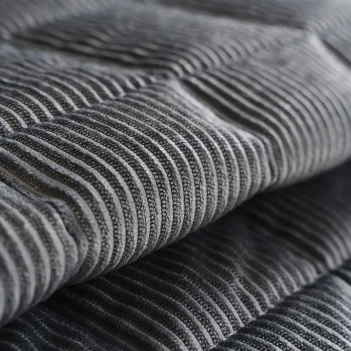 Close-up of a quilted grey microfiber couch cover mat with a ribbed texture.