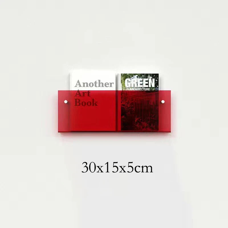 Red acrylic floating shelf holding two books, one titled "Another Art Book" and the other "GREEN ARCHITECTURE".
