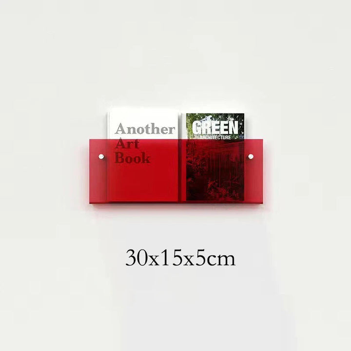 Red acrylic floating shelf holding two books, one titled "Another Art Book" and the other "GREEN ARCHITECTURE".