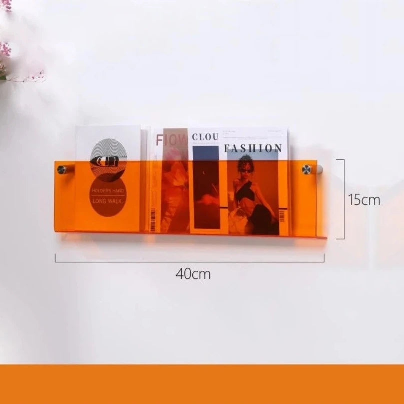 Orange acrylic floating shelf, 40cm long and 15cm high, holding magazines.