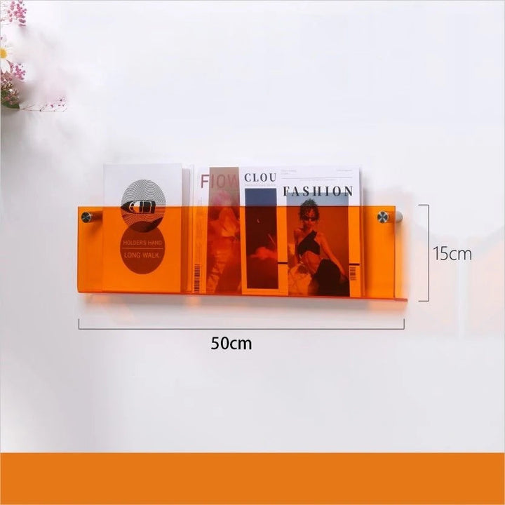 Orange acrylic floating shelf, 50cm long and 15cm high, holding magazines.