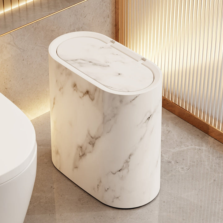 Modern marble trash can with an oval lid in a bathroom setting.
