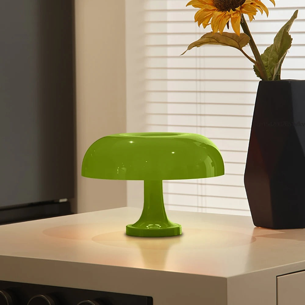 Green mushroom-shaped LED table lamp with a soft ambient glow on a white table.