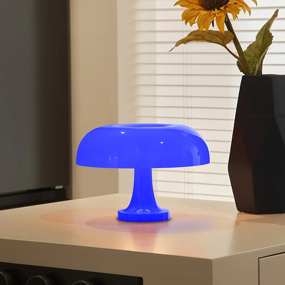 Blue mushroom-shaped LED table lamp with a soft ambient glow on a table.