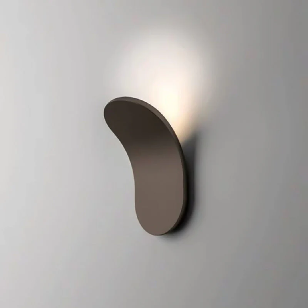 Brown minimalist LED wall sconce with a curved silhouette emitting soft light.