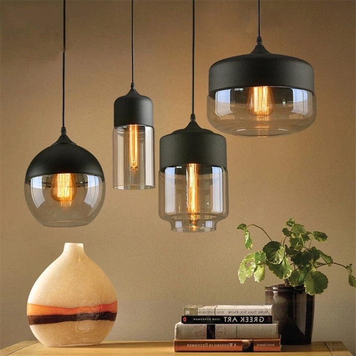 Four Nordic style pendant lights with black metal tops and clear glass shades, showing different shapes.