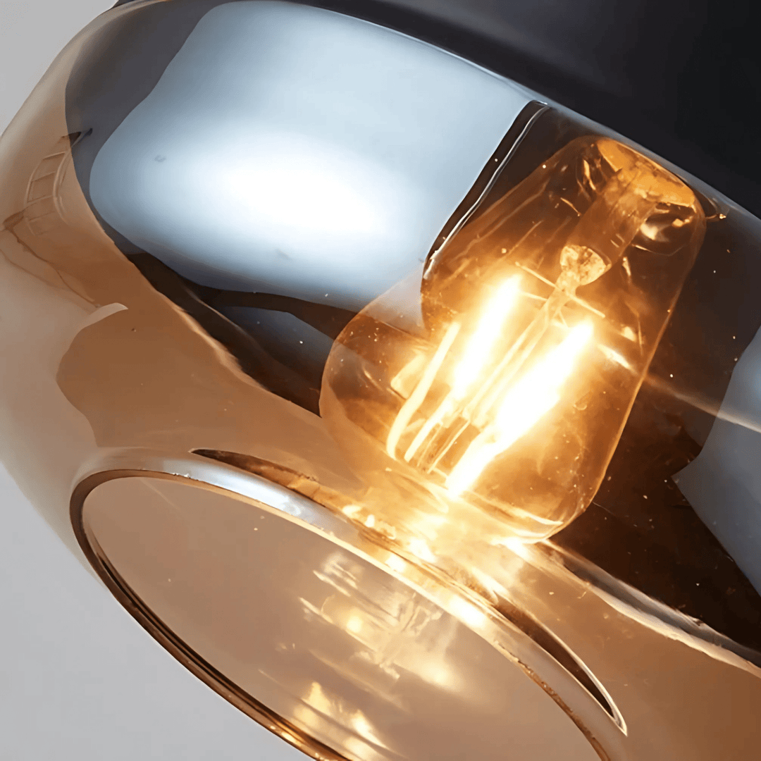 Close-up of a Nordic style pendant light with a clear glass shade and a warm Edison bulb.