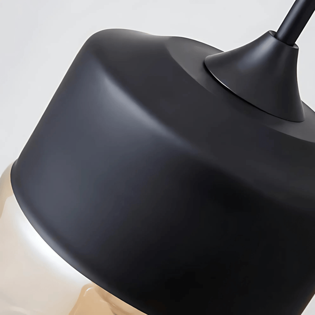 Close-up of a black metal industrial pendant light with a clear glass shade.