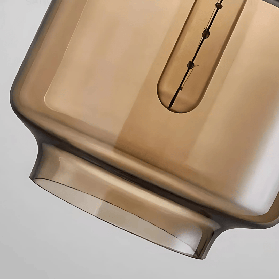 Close-up of a brown glass pendant light shade with a black filament visible inside.