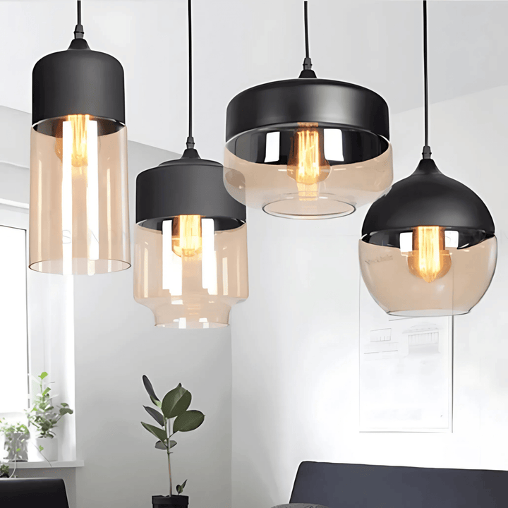 Four Nordic style pendant lights with black metal tops and amber glass shades in various shapes.