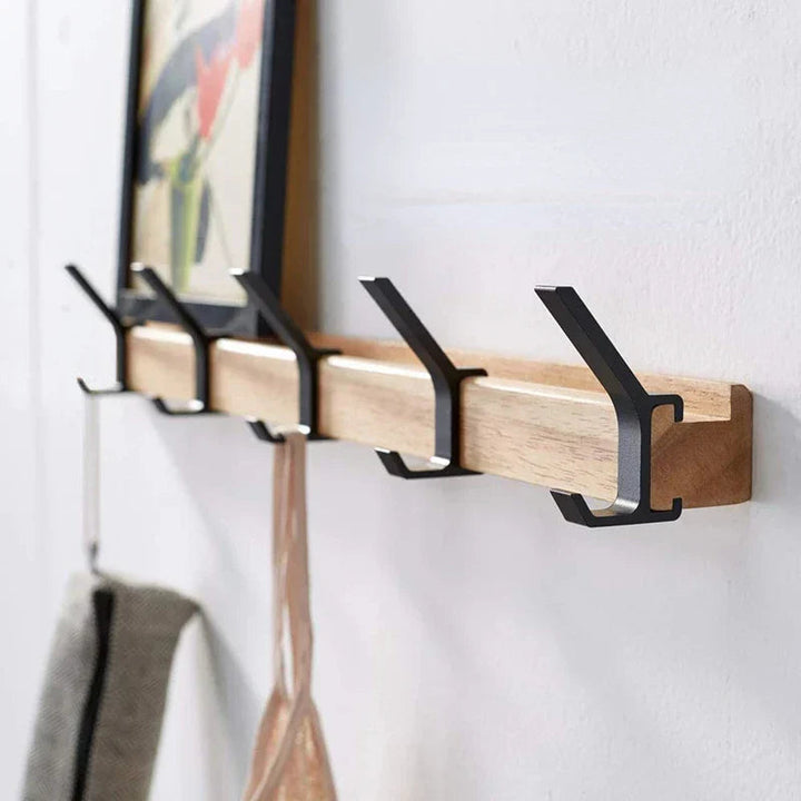 Nordic wall coat rack with natural wood and black adjustable hooks.