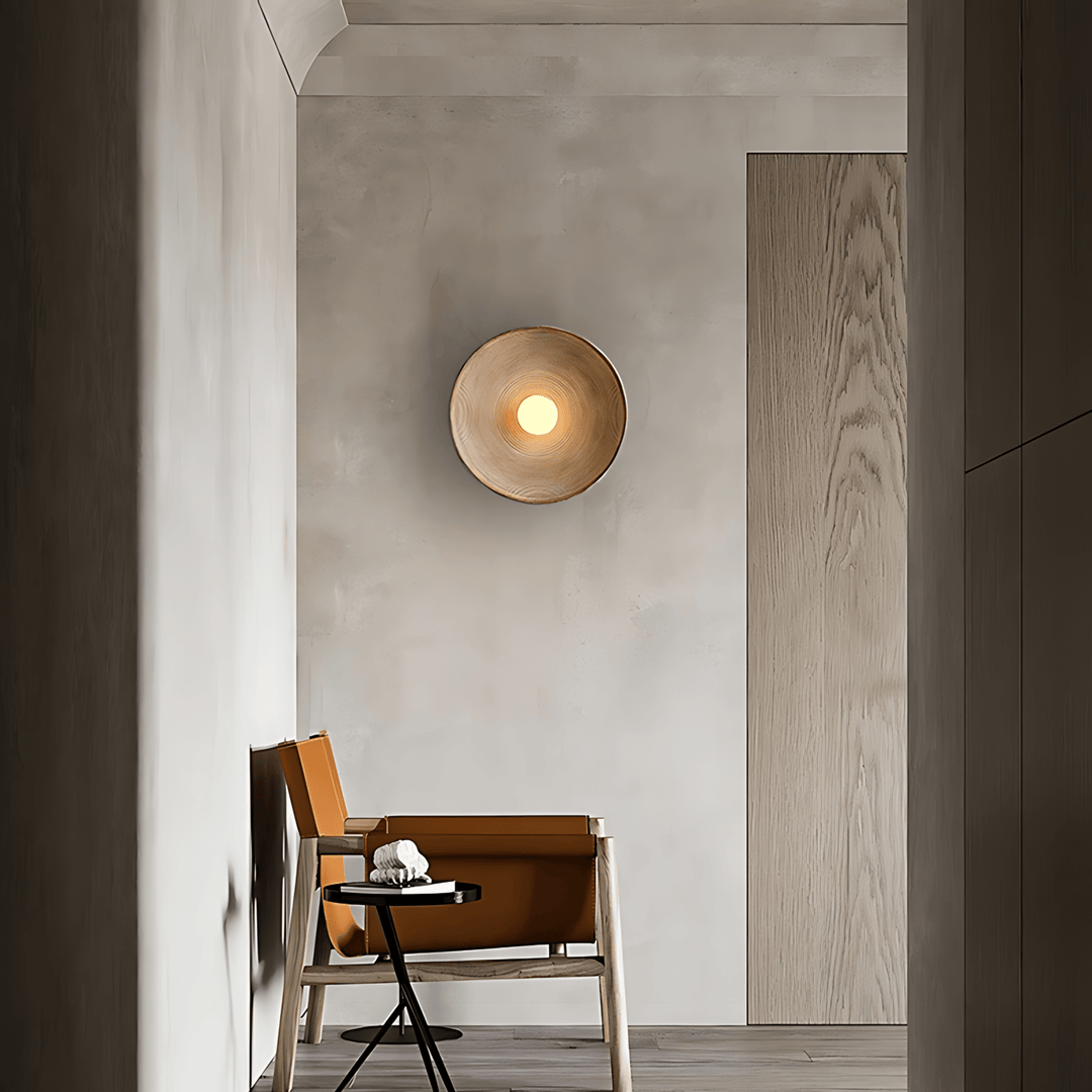Textured wall sconce with a warm light in a modern entryway.