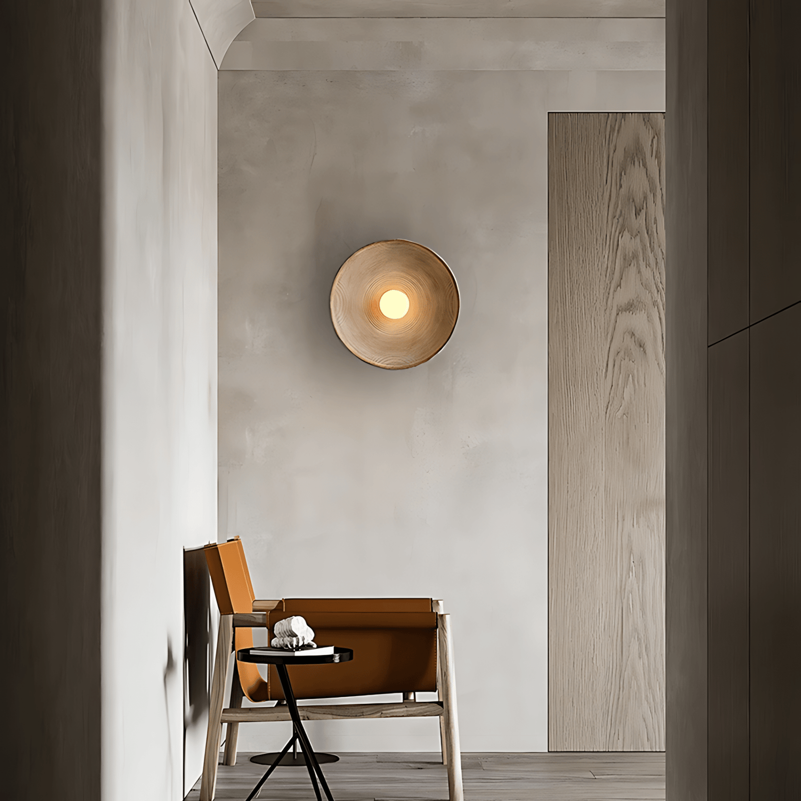 Textured wall sconce with a warm light in a modern entryway.
