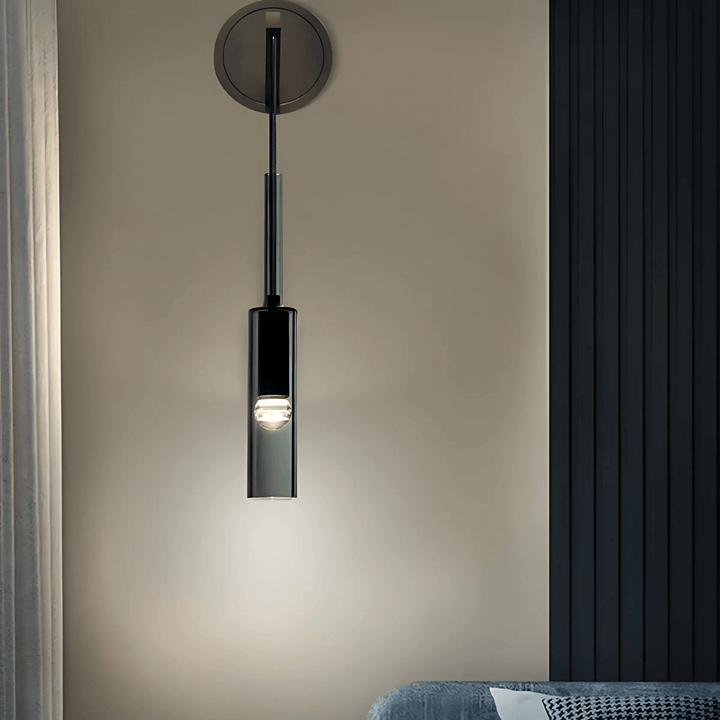 Black glass pendant light with a clear bulb, mounted on a wall.