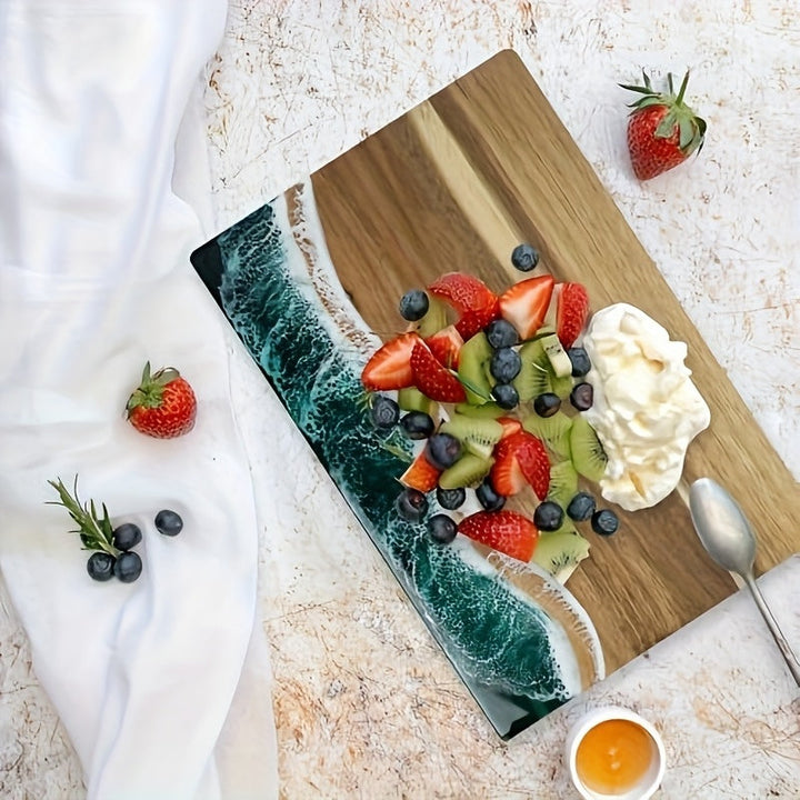 Acacia wood cutting board with a blue ocean resin wave design, topped with fruit salad and whipped cream.