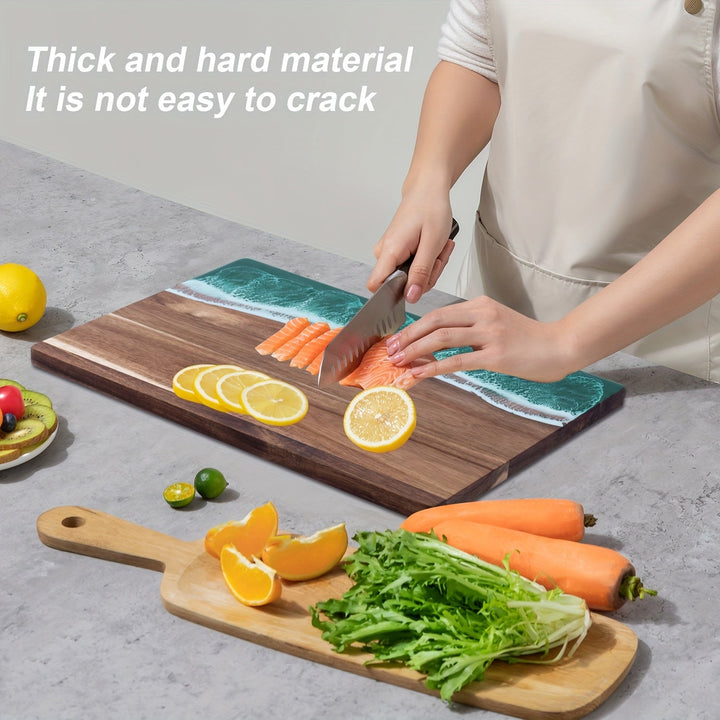 Acacia wood cutting board with a blue ocean resin inlay, featuring sliced salmon, lemons, oranges, carrots, and greens.