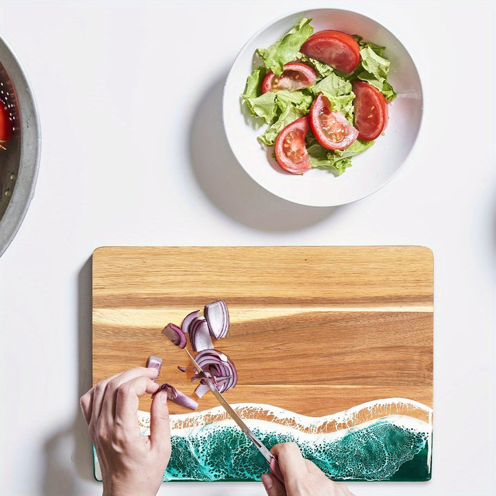 Acacia wood cutting board with a blue ocean resin wave design, chopping red onion.