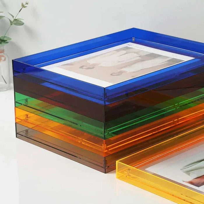Stack of colored acrylic picture frames in blue, brown, green, and orange, with a yellow frame in the foreground.