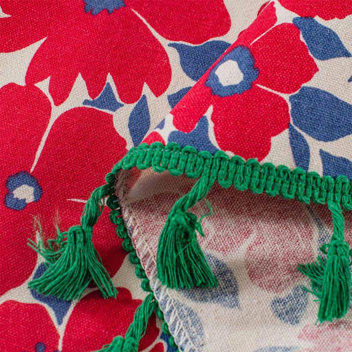 Red floral cabinet curtain with green tassel trim.