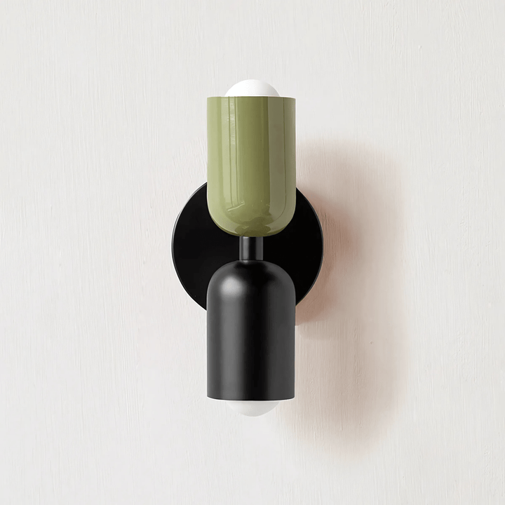 Green and black metal wall sconce with two cylindrical shades and exposed bulbs.