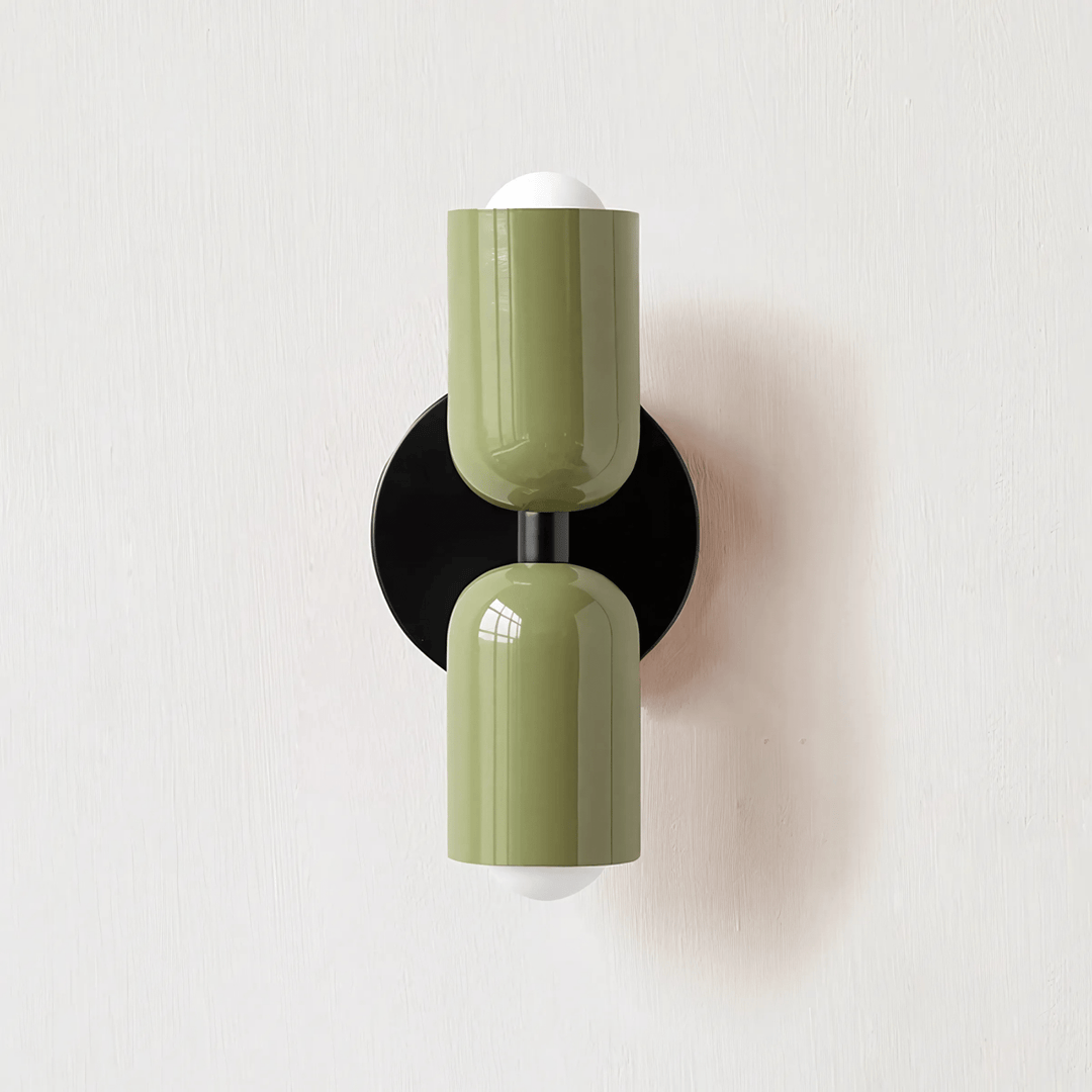 Green metal wall sconce with two cylindrical shades and exposed white bulbs.