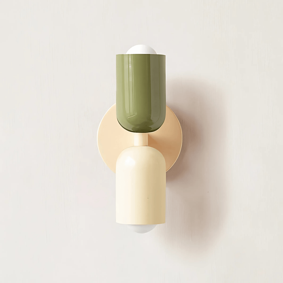 A wall sconce with a cream base and a green metal shade, mounted on a cream circular plate.