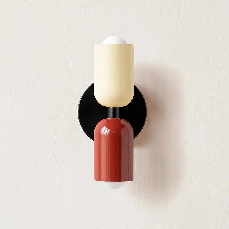 Red and cream metal wall sconce with a black circular base.