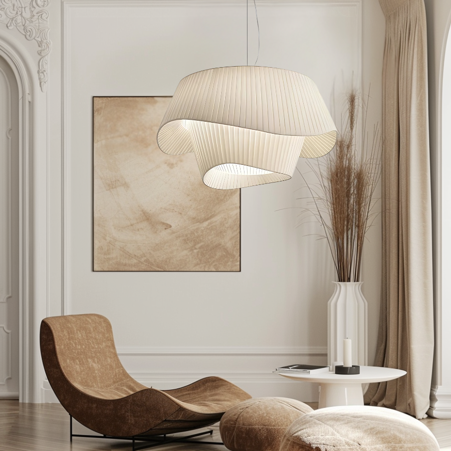 A modern, pleated pendant light with a flowing, organic shape hangs above a contemporary living space.