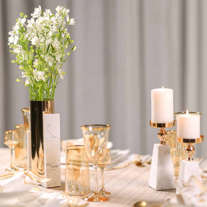 Pyramid marble candle holder with gold accents and a white pillar candle.