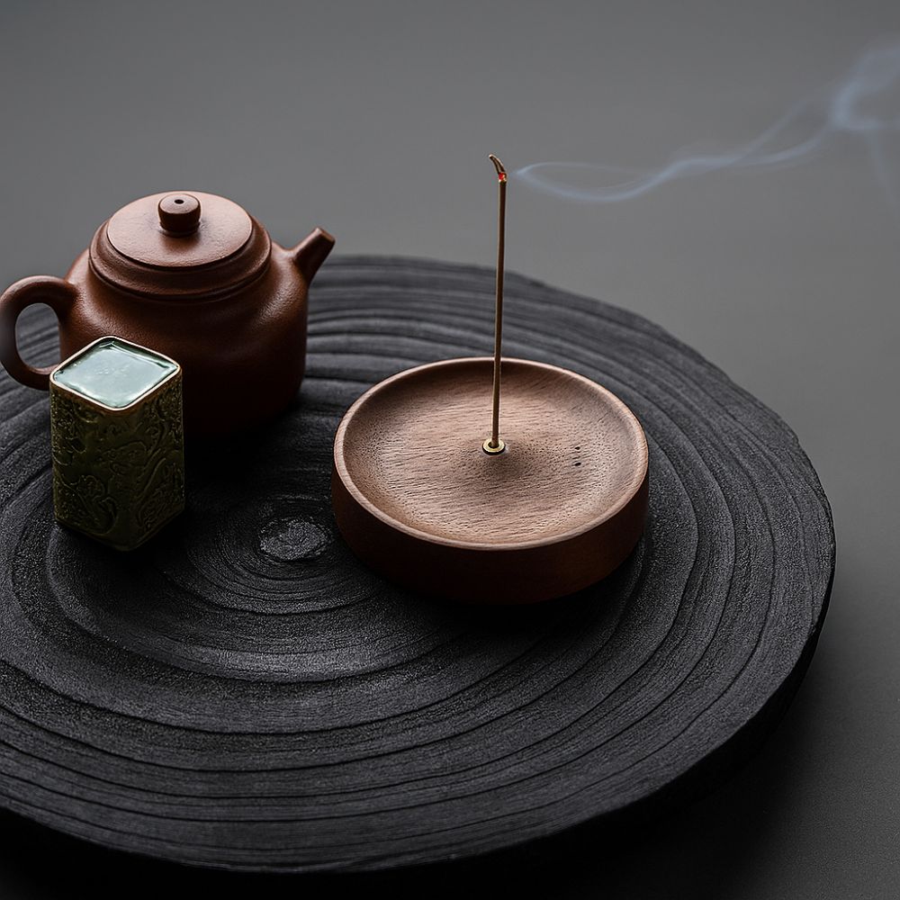 Round wood incense holder with an incense stick burning and emitting smoke.