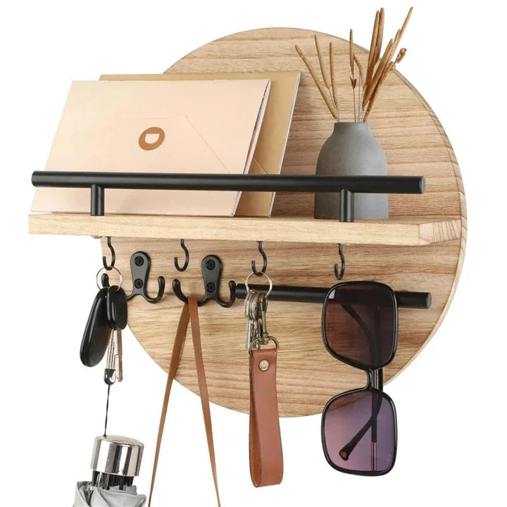 Round wooden key holder with shelf, hooks for keys, sunglasses, and a vase with dried reeds.
