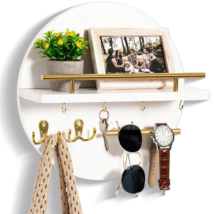 Round wooden key holder with shelf, gold bar, hooks, plant, photo frame, keys, sunglasses, and watch.