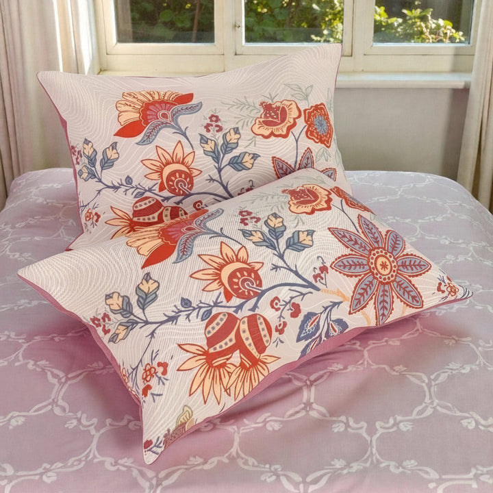 Two rustic floral boho pillowcases with a pink patterned sheet.