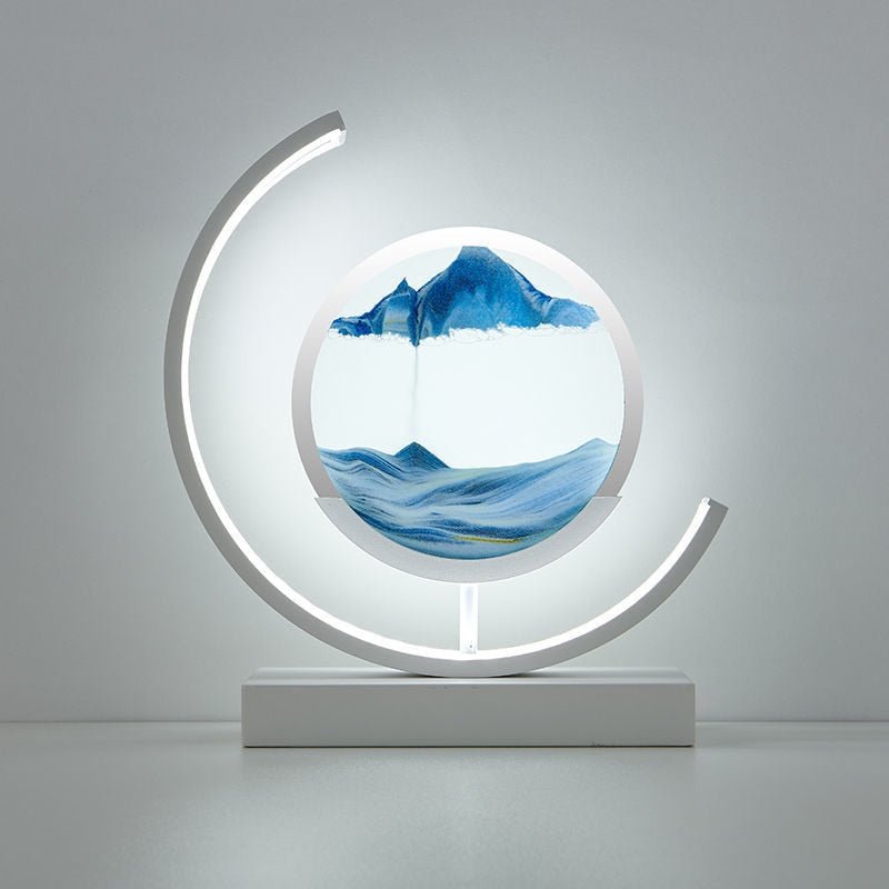 Modern white lamp with a circular glass enclosure containing flowing blue sand art.