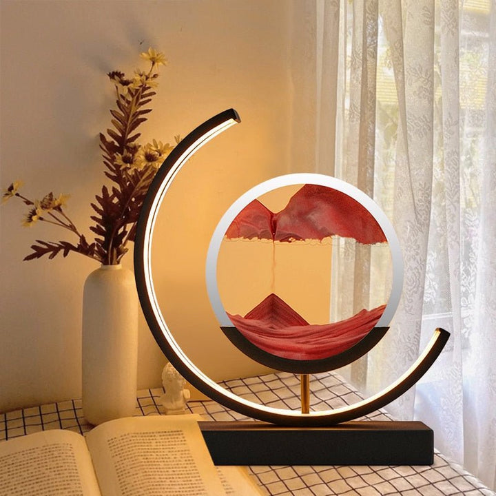 Modern crescent lamp with a circular sand art display showing red sand falling.
