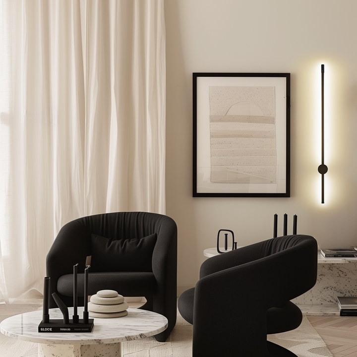 Black satin wall sconce with a sleek, modern design, illuminating a wall.