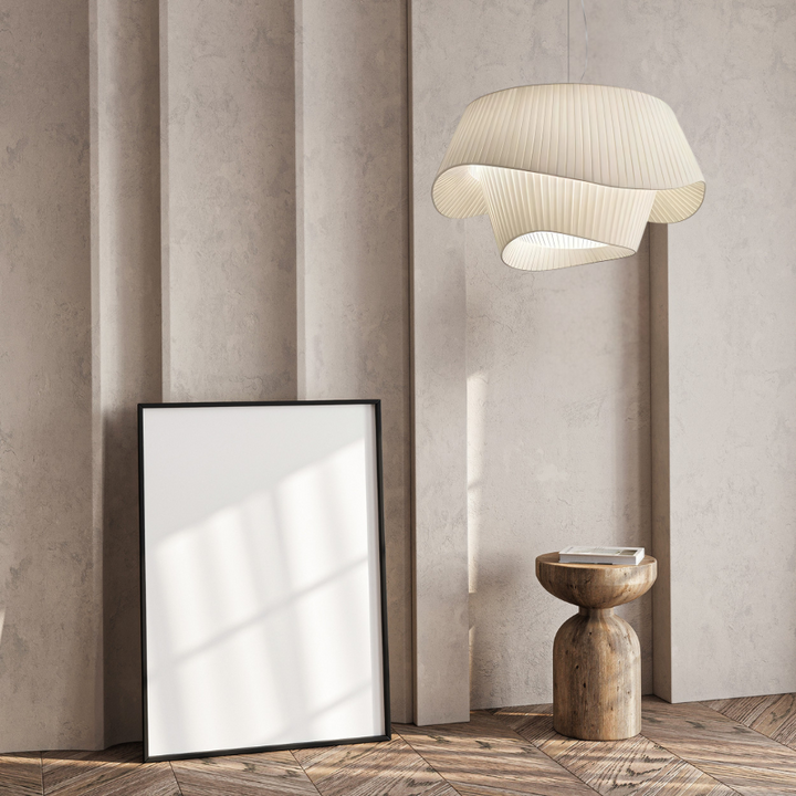 White acrylic pendant light with a sail shape hanging over a wooden side table.