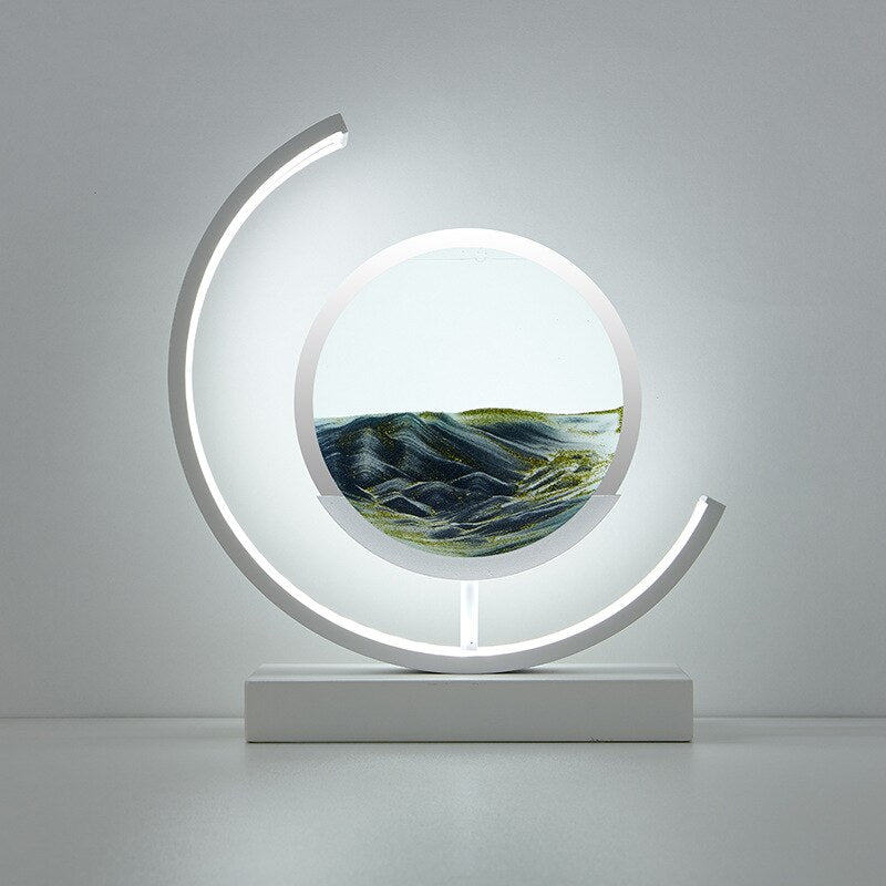Modern white crescent lamp with a circular glass enclosure containing flowing 3D quicksand art.