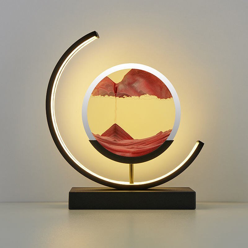 Modern LED table lamp with a circular sand art display and a curved light.
