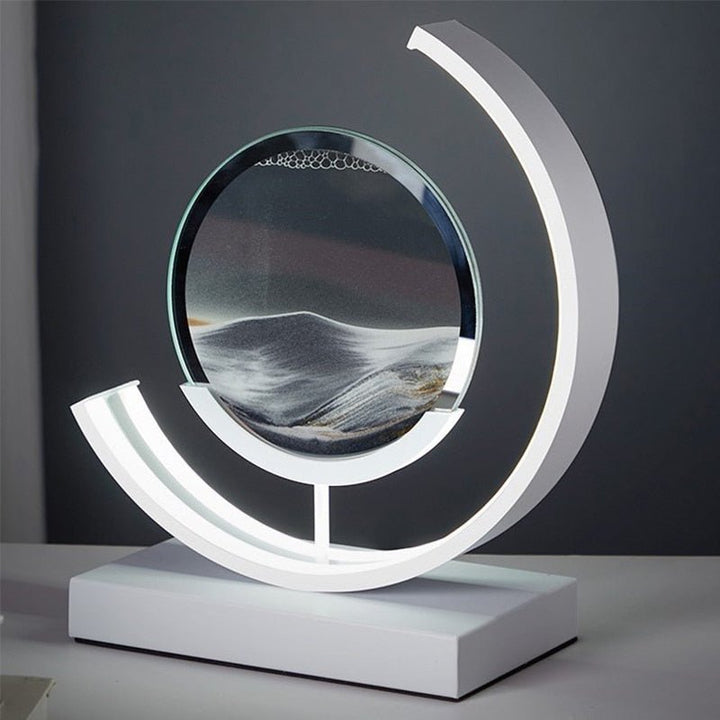 Modern white LED table lamp with a circular glass enclosure filled with flowing sand art.