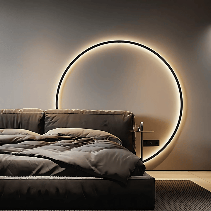 Modern circular wall sconce with dimmable ambient lighting above a bed.