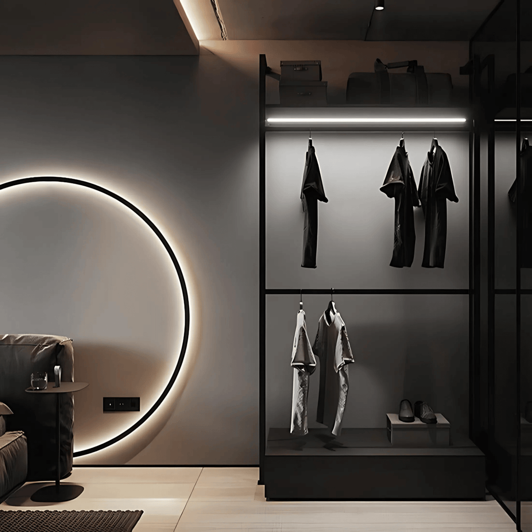 Modern bedroom with a circular wall sconce and a closet with hanging clothes.