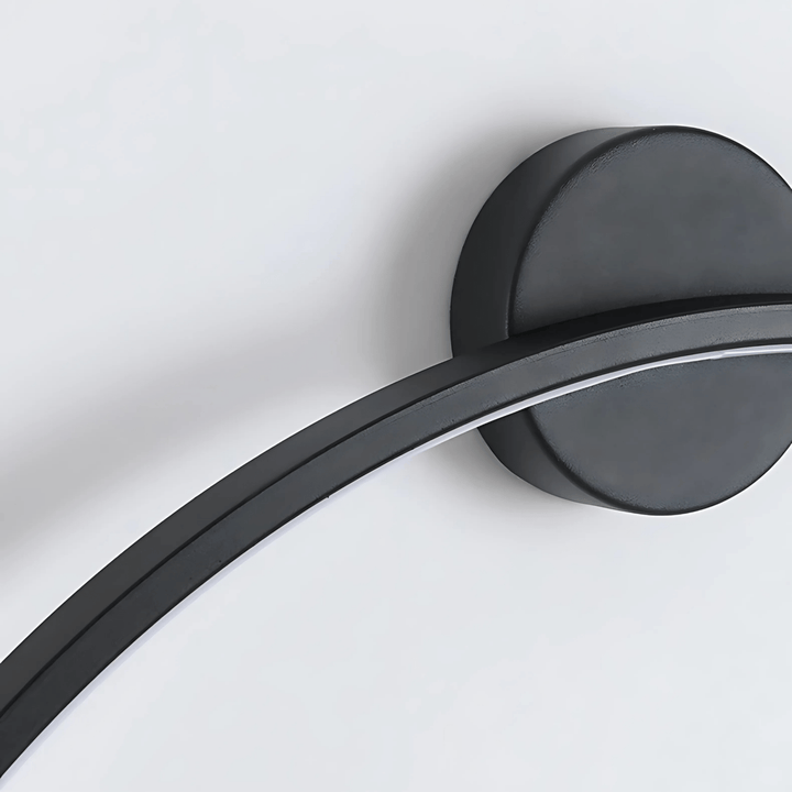 Black modern wall sconce with a curved arm and a circular base against a white background.