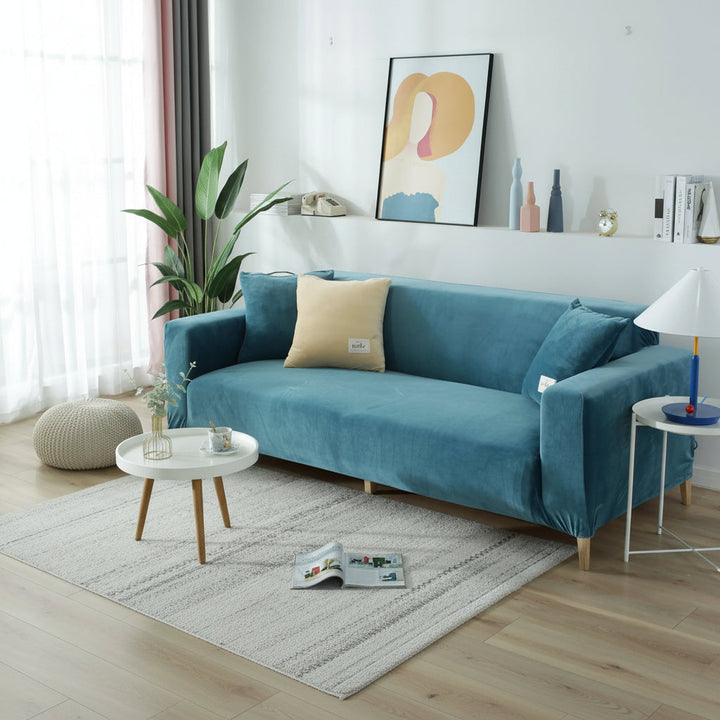 Lake blue velvet couch cover on a sofa with a light-colored rug and coffee table.