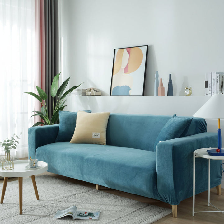 Lake blue velvet couch cover with a light beige throw pillow on a sofa.