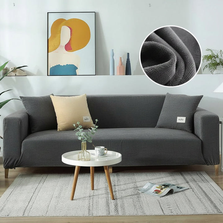 Dark gray velvet couch cover with a light beige pillow and a dark gray pillow.